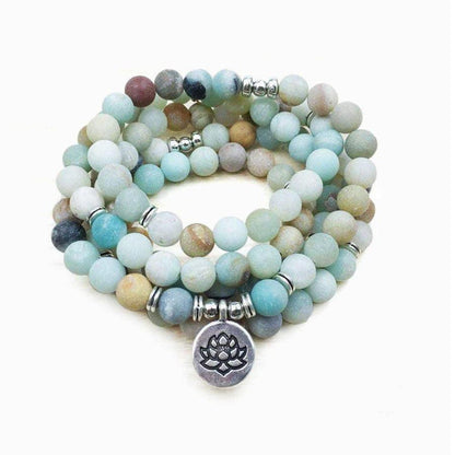 Mala en amazonite posé sur une surface en bois clair