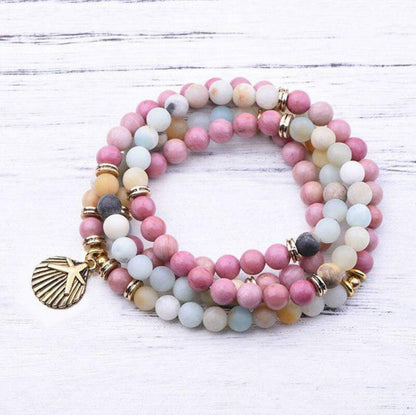 Collier mala en amazonite posé sur une surface claire