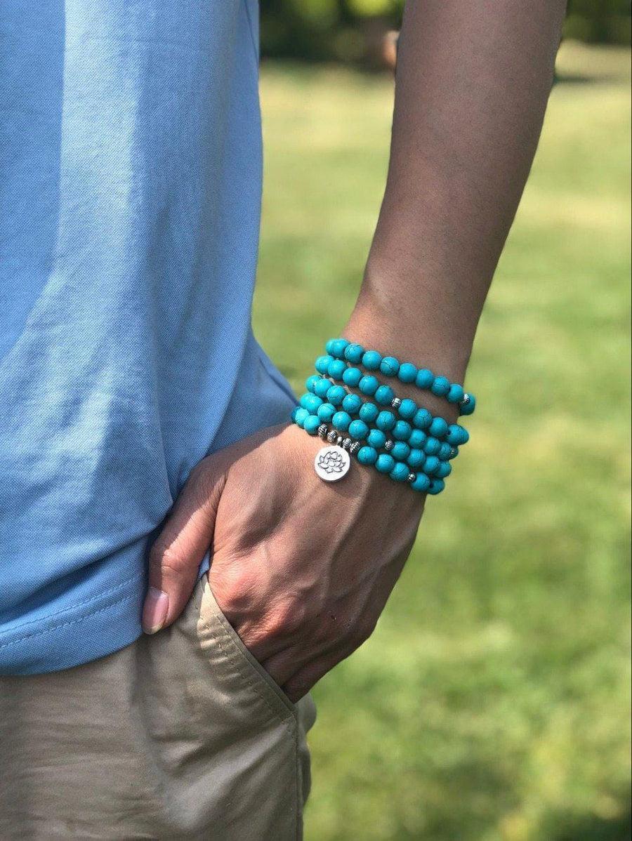 Détail des perles turquoise du mala avec symbole lotus