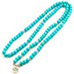 Vue rapprochée du mala turquoise et de son pendentif lotus