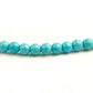 Mala turquoise posé sur une surface en bois clair