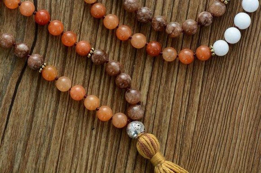 Mala en agate avec perles de cuivre sur fond blanc