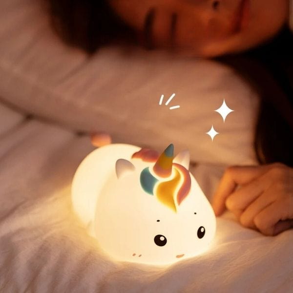 Veilleuse licorne allumée sur une table de nuit
