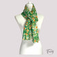 Foulard vert floral enroulé, mettant en valeur sa légèreté