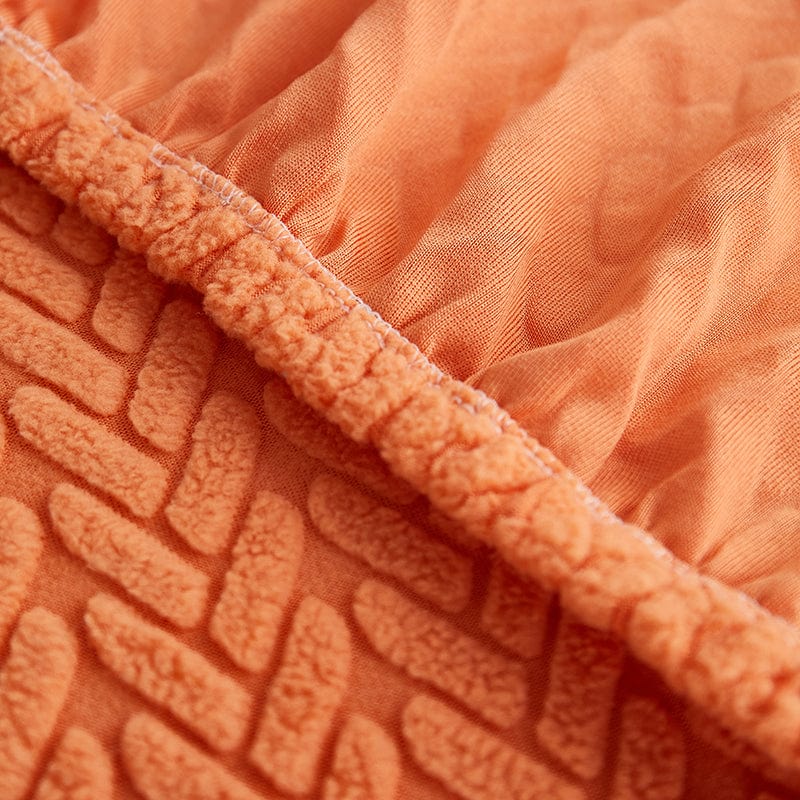 Housse polaire orange enveloppant un coussin, vue de dessus