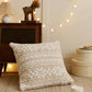 Oreiller beige avec flocons blancs sur canapé