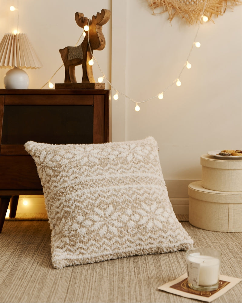 Oreiller beige avec flocons blancs sur canapé