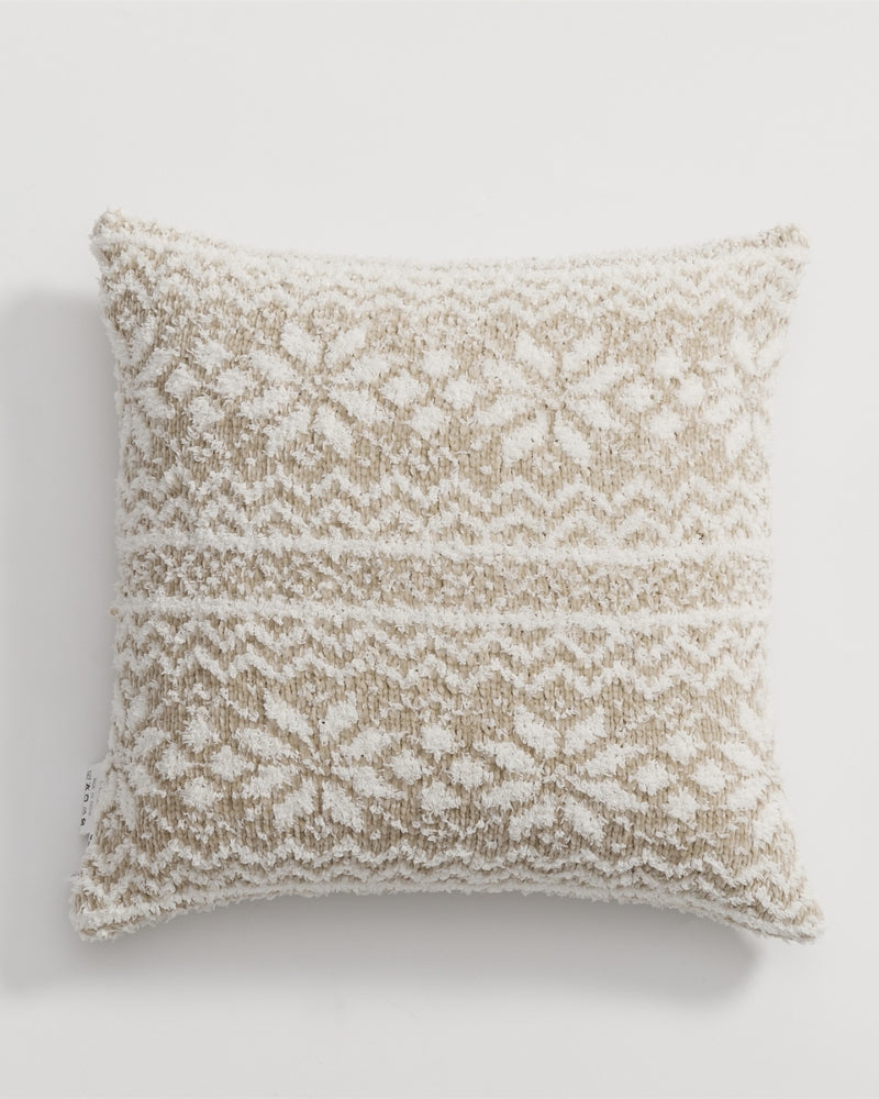 Oreiller décoratif beige et blanc sur lit