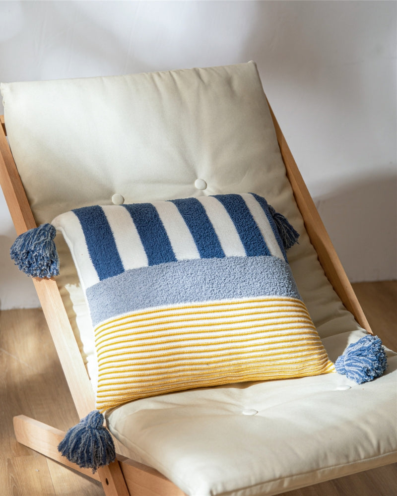 Gros plan sur les pompons et bandes bleues de l'oreiller