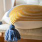 Oreiller marinière en duvet sur un canapé, pompons visibles