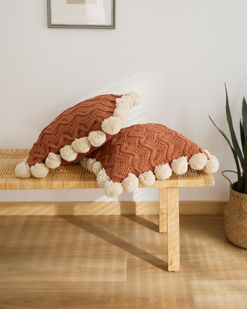 Gros plan sur les pompons beiges de l'oreiller en peluche