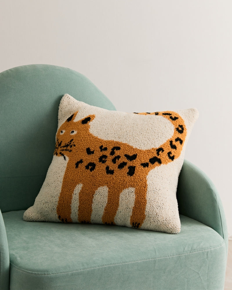 Oreiller Pilou Pilou sur lit, motif animalier
