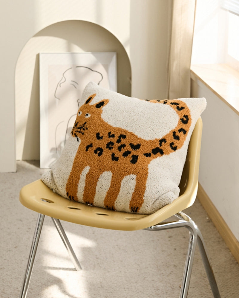 Oreiller motif tigre sur canapé vert d'eau