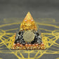 Pyramide orgonite avec obsidienne et feuille d'or en gros plan