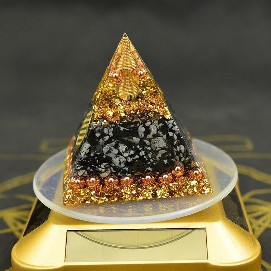 Vue latérale d'une pyramide orgonite avec médaillon doré