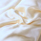 Ensemble de literie beige clair, drapé sur un lit