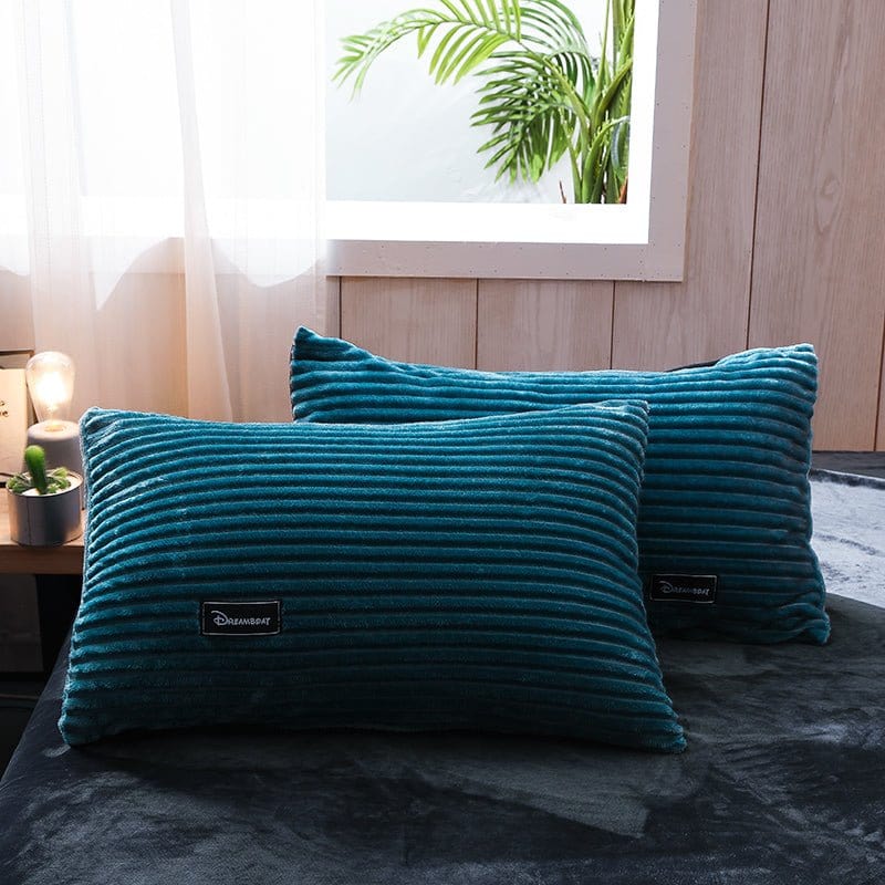 Ensemble de lit en velours bleu turquoise sur un lit