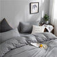 Ensemble de lit gris clair installé sur un lit double