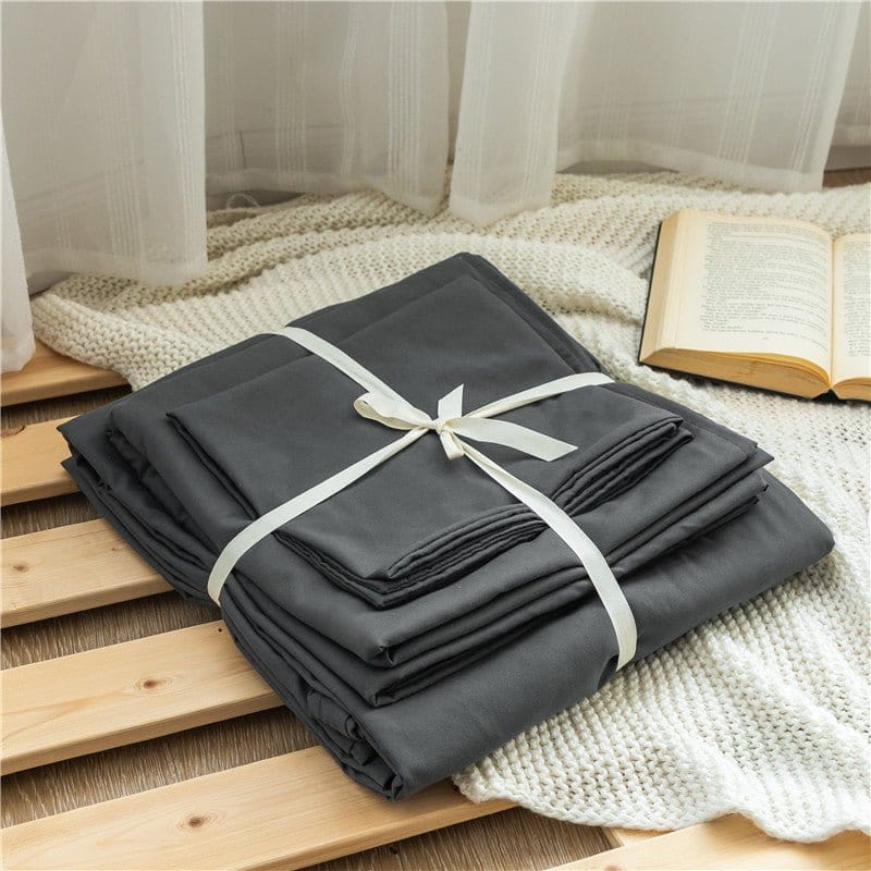 Vue d'ensemble d'un lit avec draps gris et taies assorties