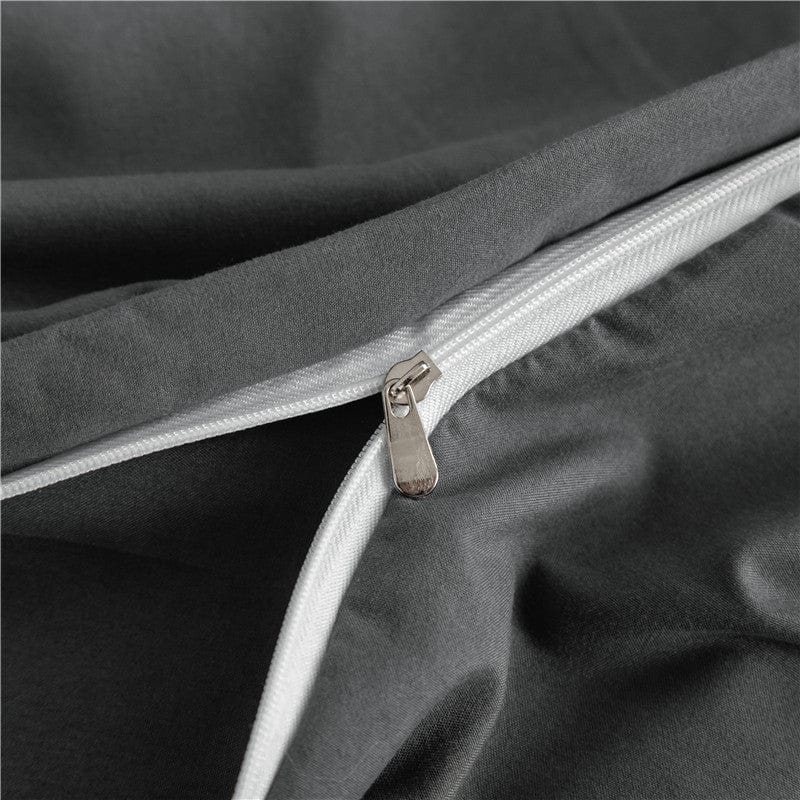 Détail des coins élastiques du drap-housse gris sur un matelas