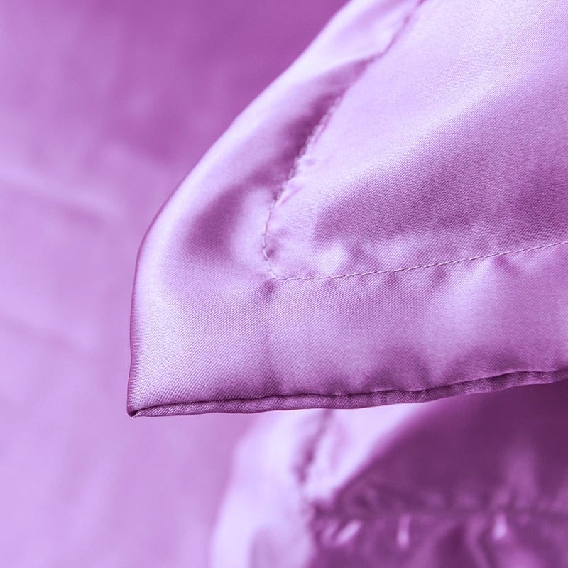 Détail des coutures fines sur la housse de couette mauve