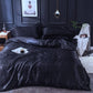 Parure de lit noire sur un lit, montrant sa texture lisse