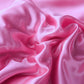Ensemble de lit en satin rose sur un lit bien fait