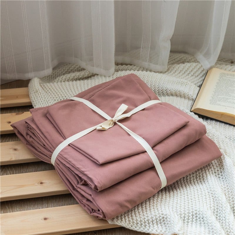 Vue d'ensemble d'une parure de lit rose pêche avec drap et housse