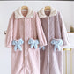 Peignoir mauve avec col blanc et boutons visibles