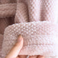 Peignoir rose plié sur une étagère en bois