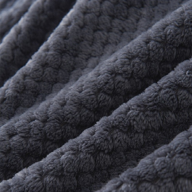 Peignoir gris plié sur un lit, ambiance cosy