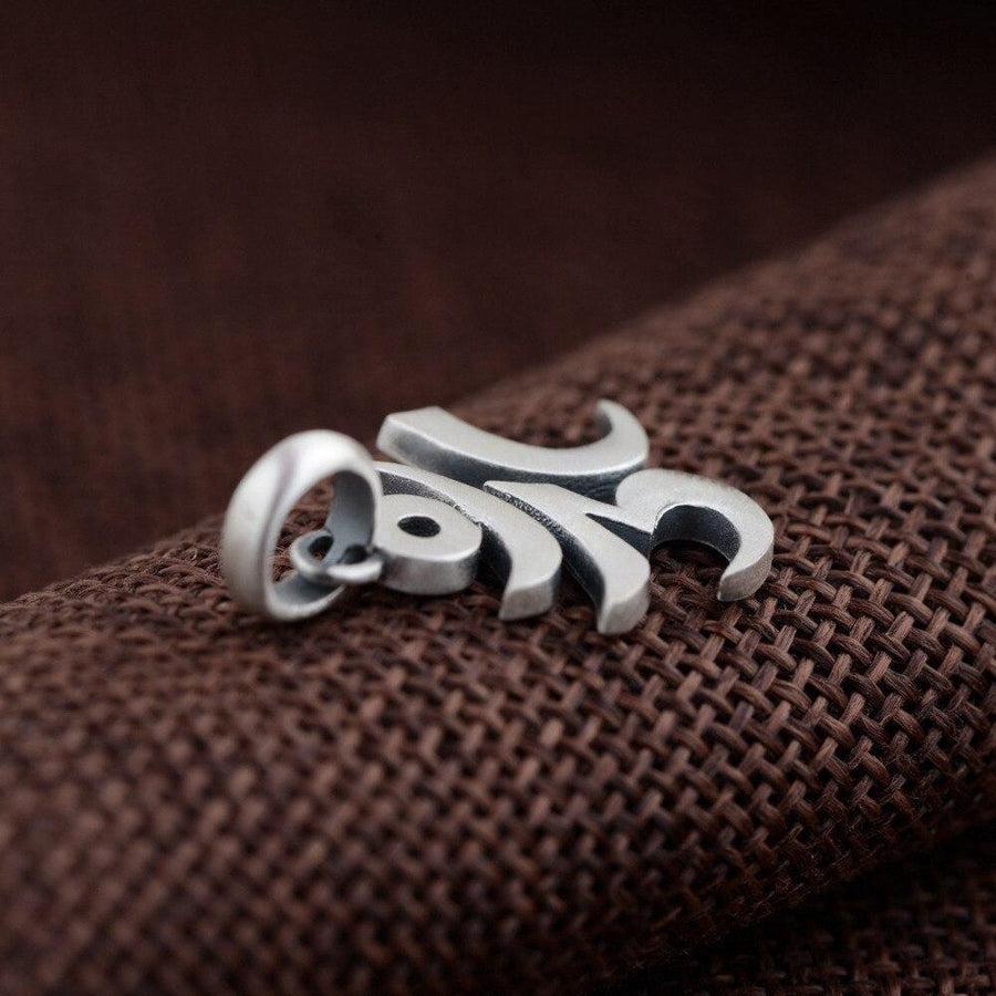 Gros plan du symbole Aum en argent poli