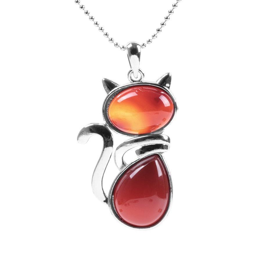 Gros plan sur le pendentif chat et pierre ambrée