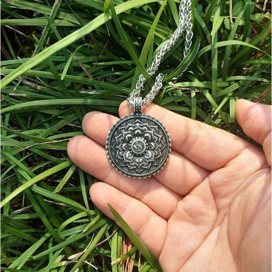 Détail du motif floral sacré sur le pendentif tibétain