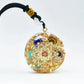Gros plan sur le pendentif orgonite avec détails métalliques visibles