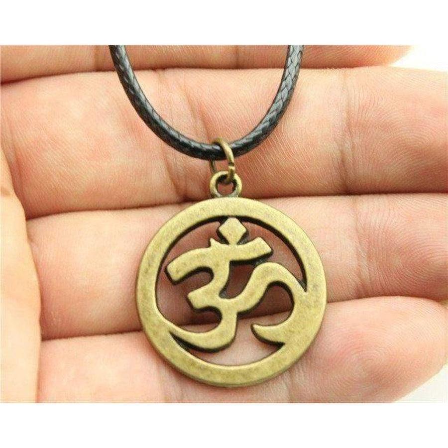 Pendentif Om suspendu à une chaîne, capturant la lumière
