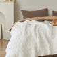 Plaid blanc doux drapé sur un canapé gris