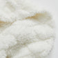 Détail des fibres du plaid blanc, aspect moelleux