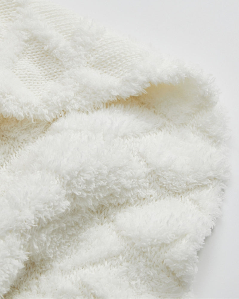 Détail des fibres du plaid blanc, aspect moelleux