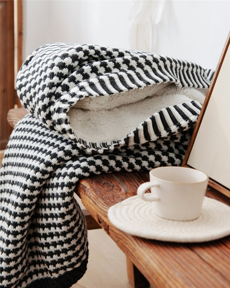 Plaid à carreaux noir et blanc sur canapé gris