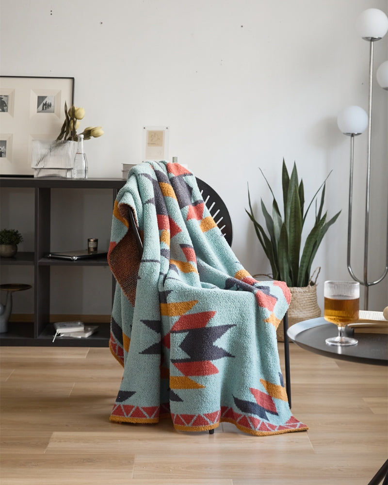 Plaid turquoise avec motifs ethniques sur un canapé