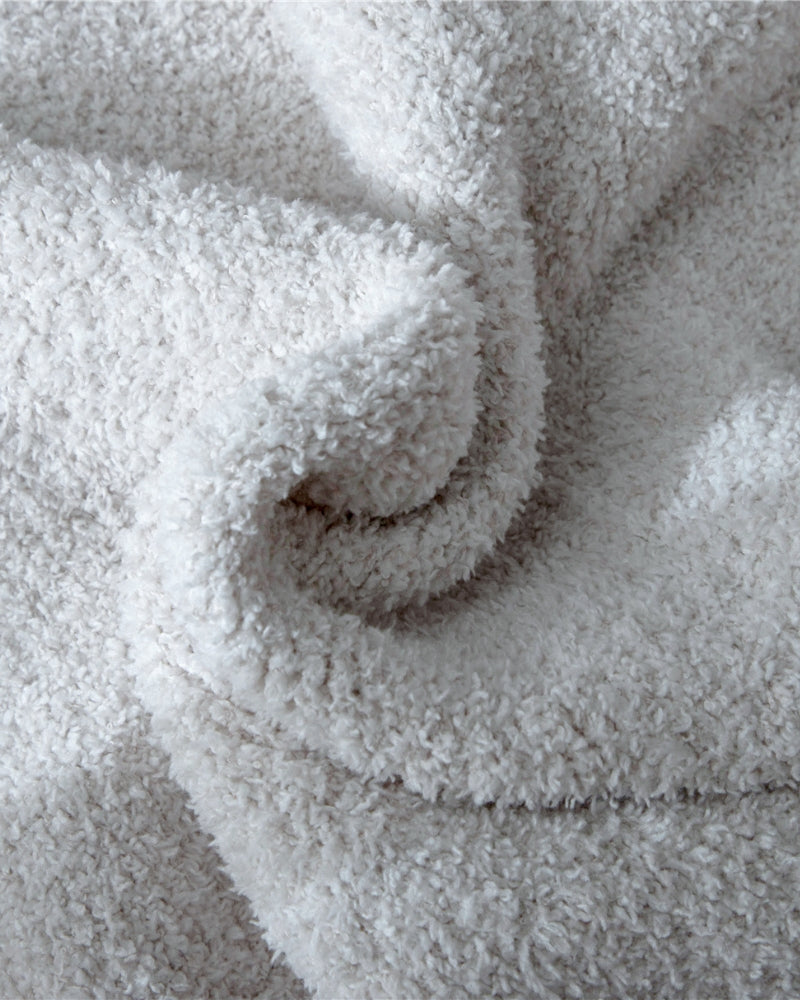 Plaid blanc drapé sur une méridienne élégante