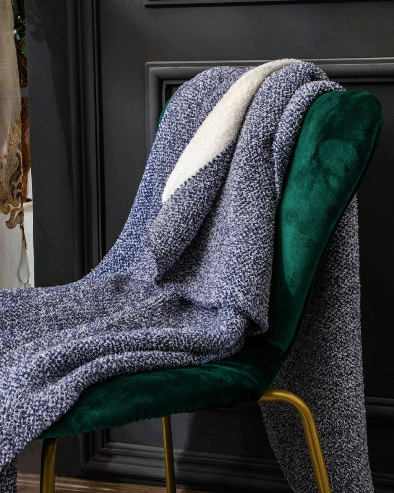 Plaid blanc soigneusement plié sur un lit