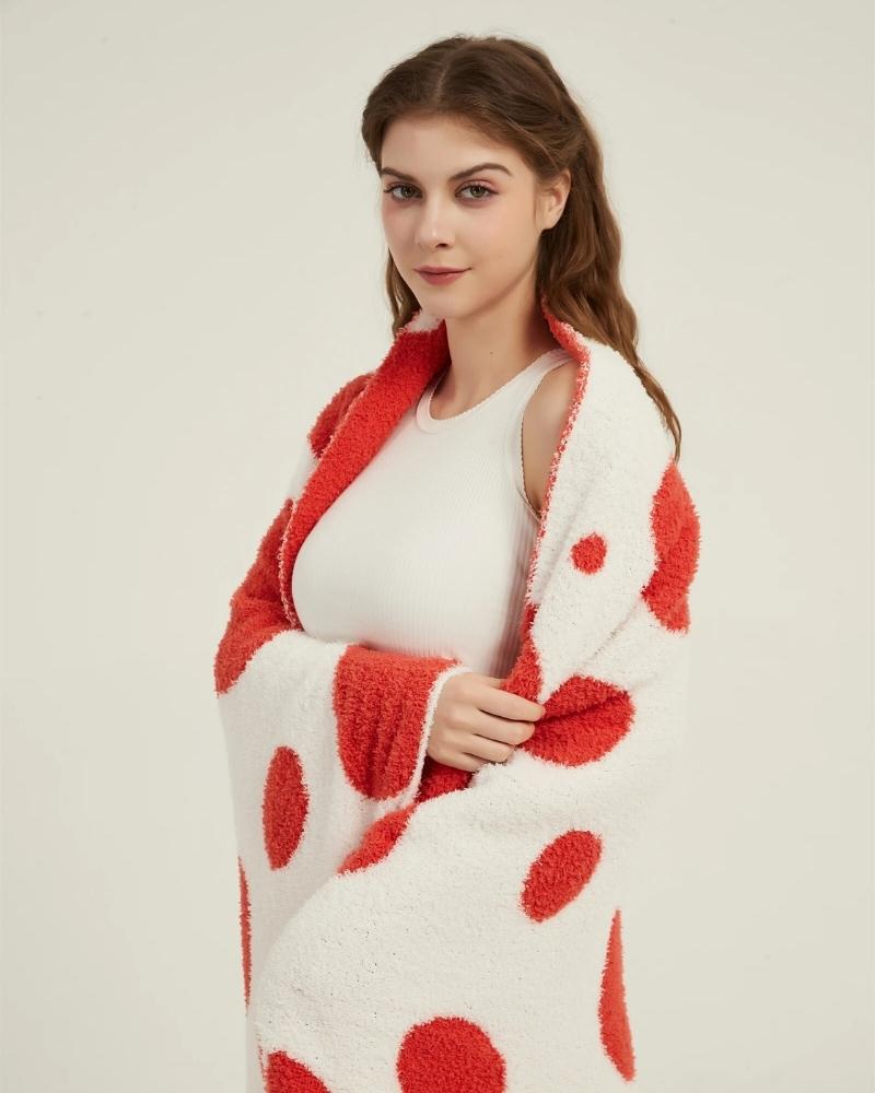 Plaid réversible rouge et blanc en fausse fourrure sur canapé