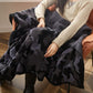 Plaid noir en fausse fourrure sur canapé moderne
