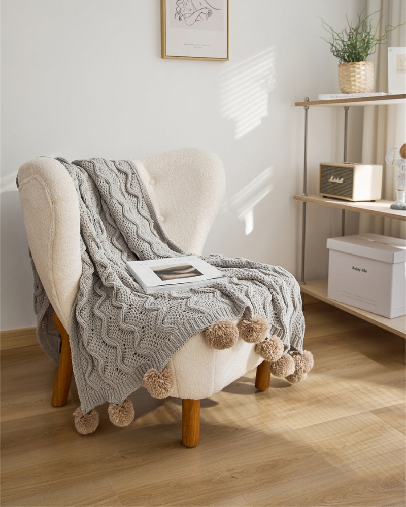 Ambiance cosy avec plaid gris sur canapé clair