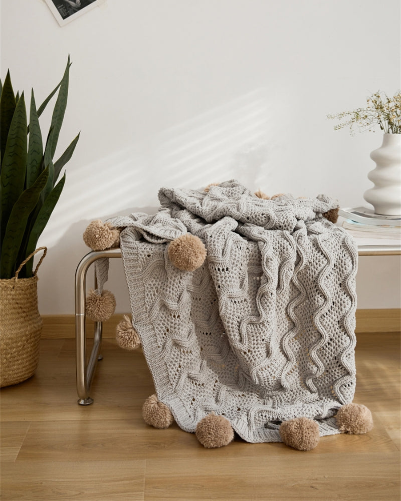 Détail des pompons en fourrure marron du plaid