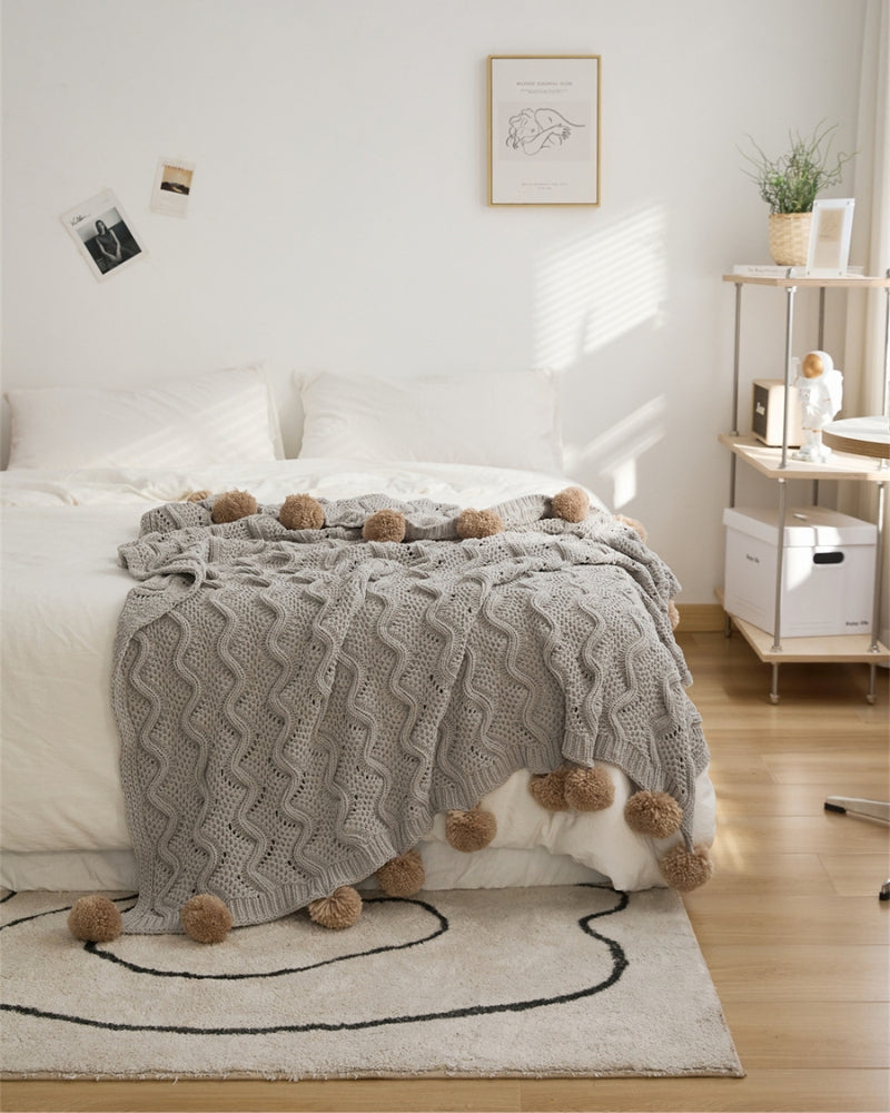 Plaid gris étalé sur un fauteuil crème élégant
