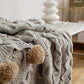 Texture douce du plaid gris avec pompons en fourrure