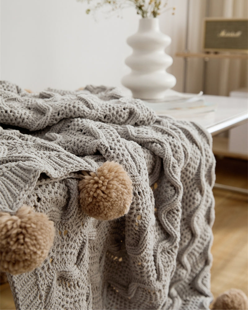 Texture douce du plaid gris avec pompons en fourrure
